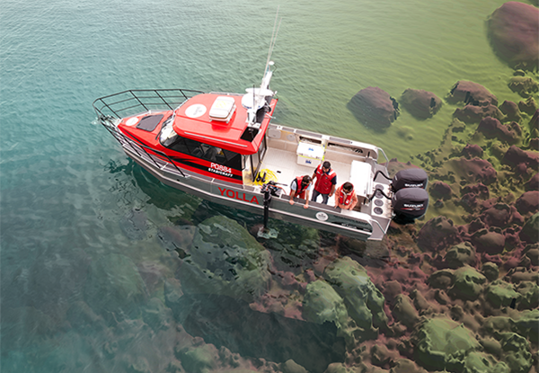 Scientists on a boat in shallow water